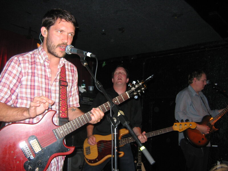 Man Playing Guitar on Stage — Black, Energetic, Night, Photograph, Microphone, Band