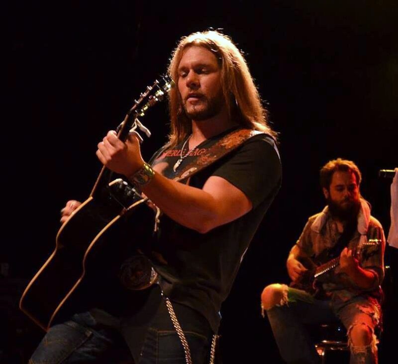 Man Playing Guitar on Stage — Black, Focused