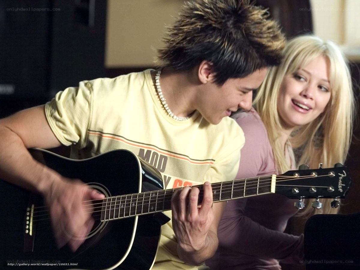 man playing guitar with woman