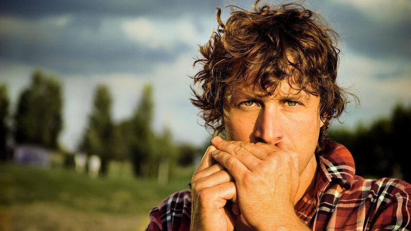 man playing harmonica outdoors