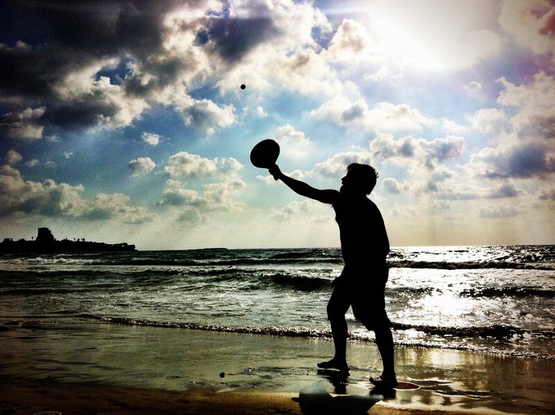 Man playing paddle on beach