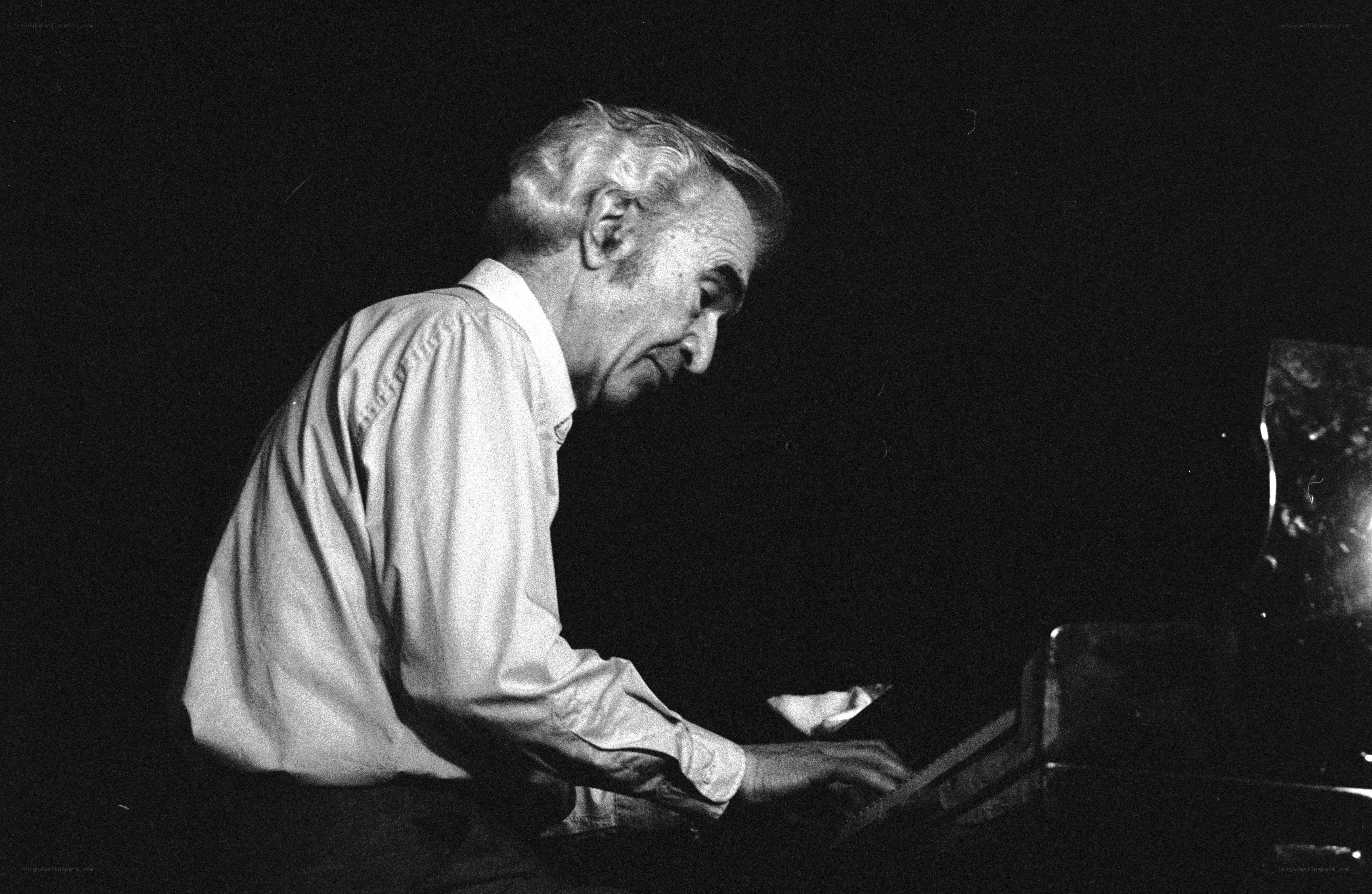 man playing piano in dim light