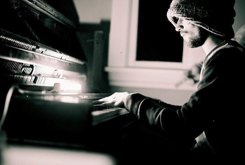 man playing piano in dim light