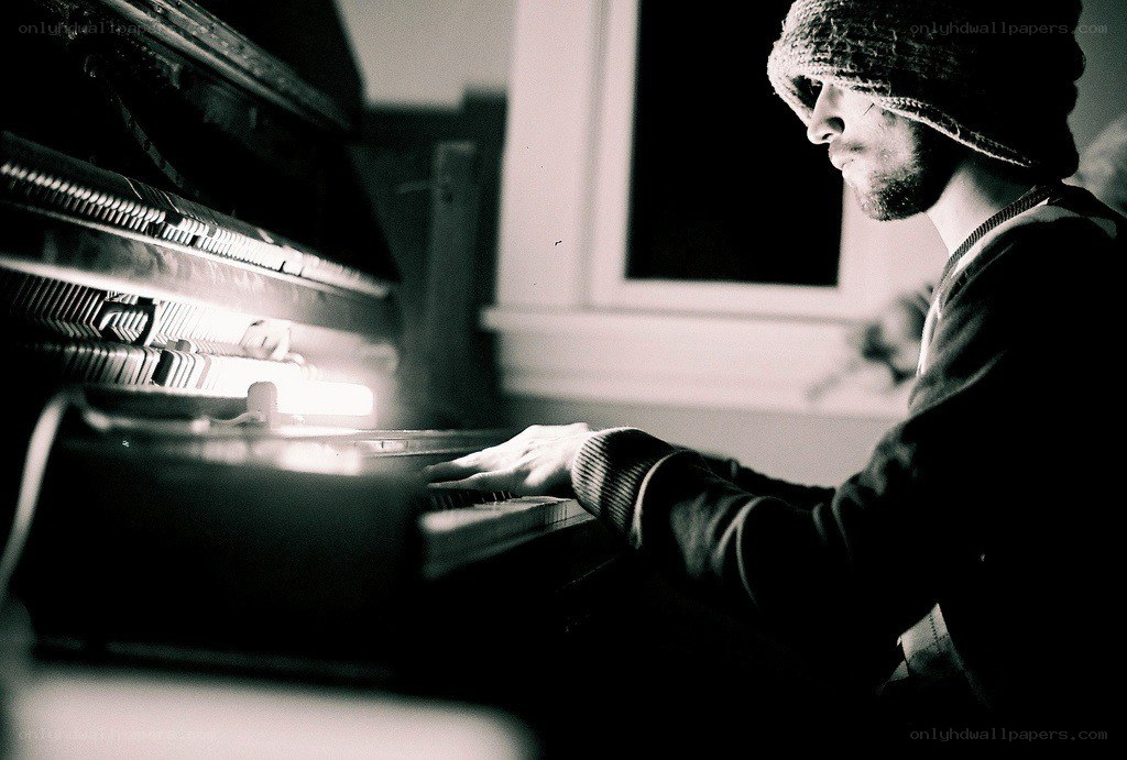 man playing piano in dim light