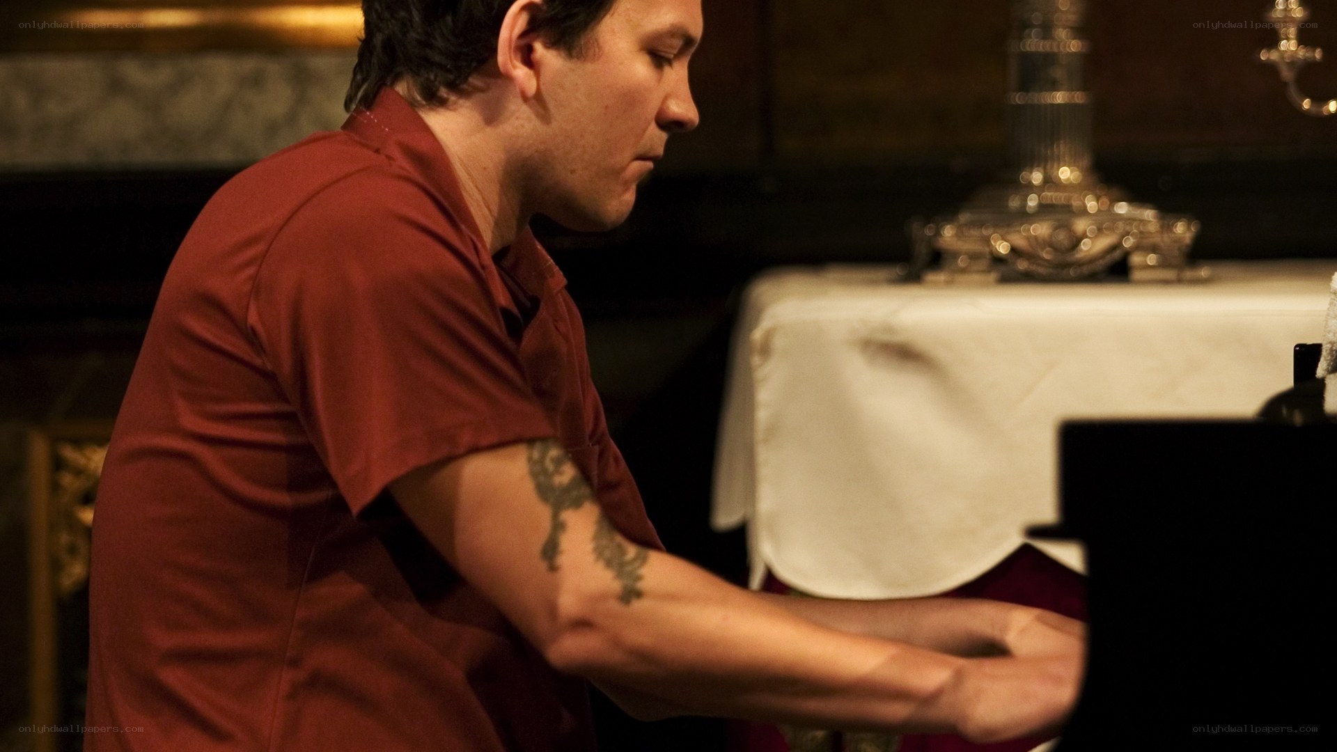 man playing piano in red shirt