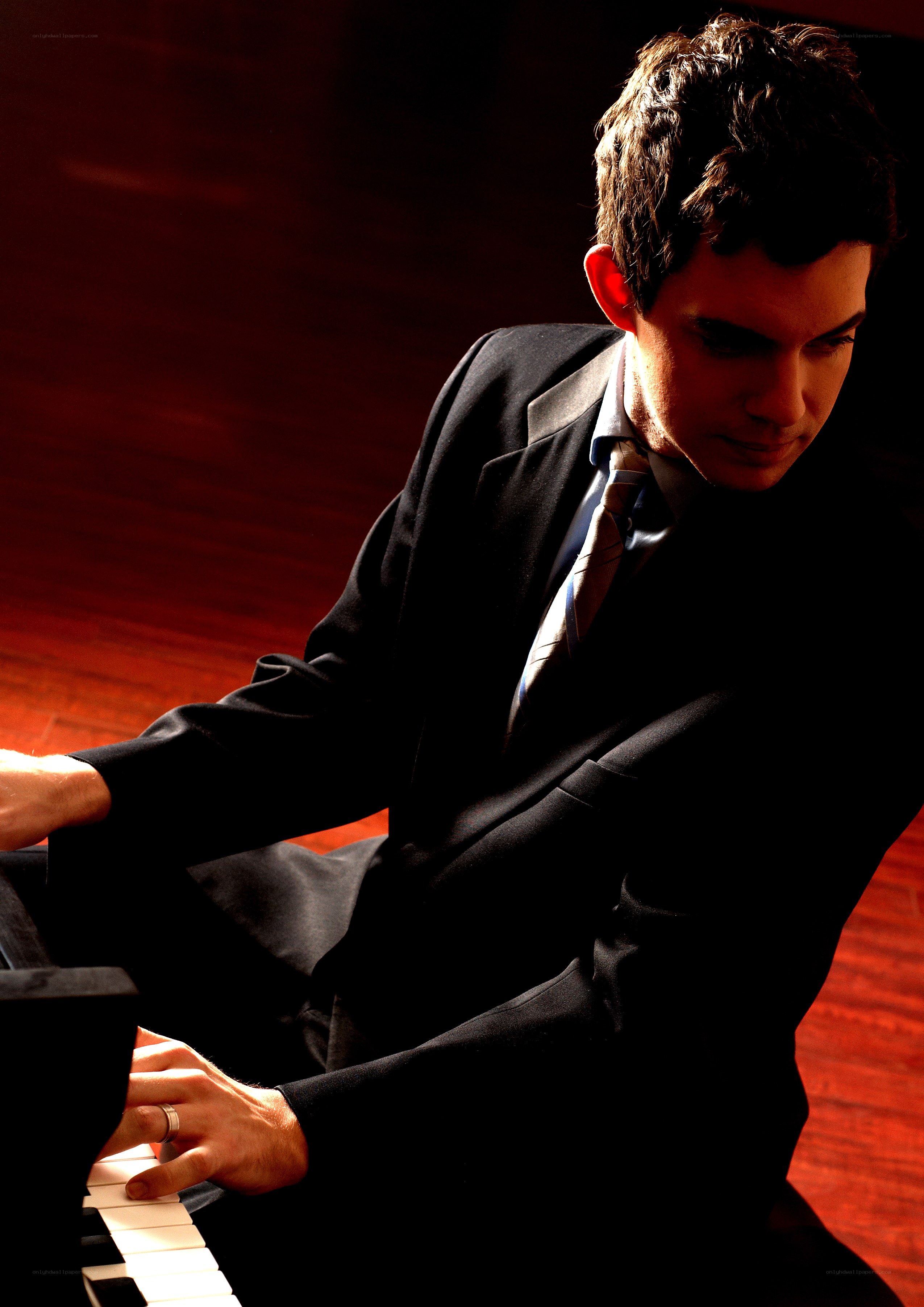 man playing piano in suit