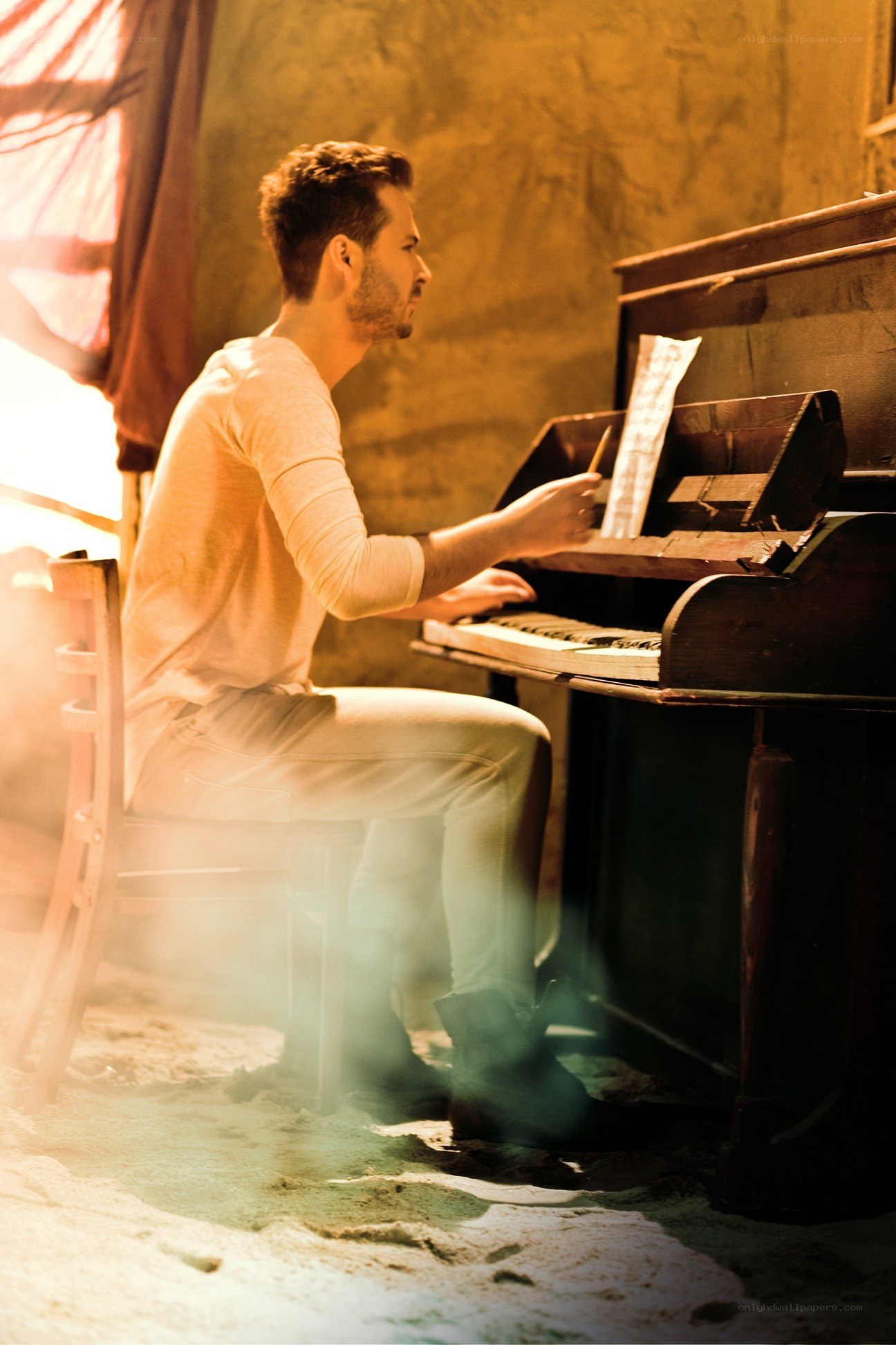 Man playing piano in warm light