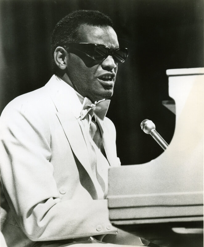 man playing piano in white suit