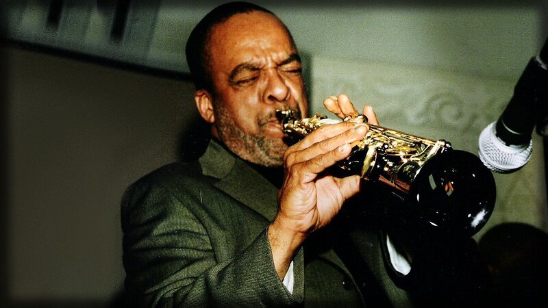 Man Playing Saxophone — Green, Focused