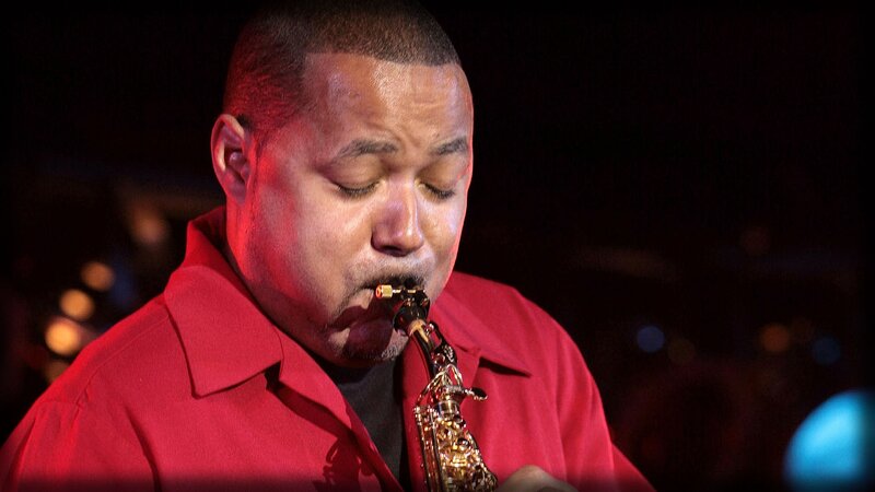 Man Playing Saxophone — Red, Focused