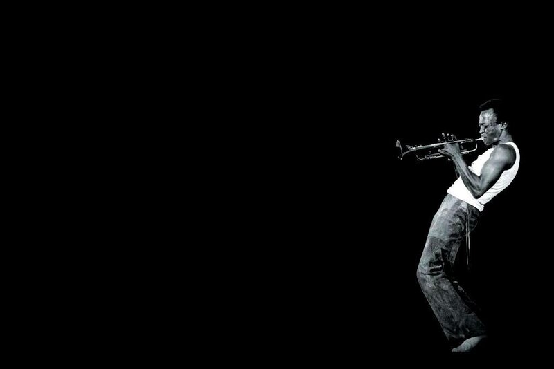 Man playing trumpet on black background