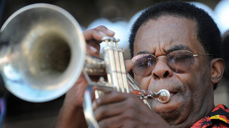 man playing trumpet outdoors
