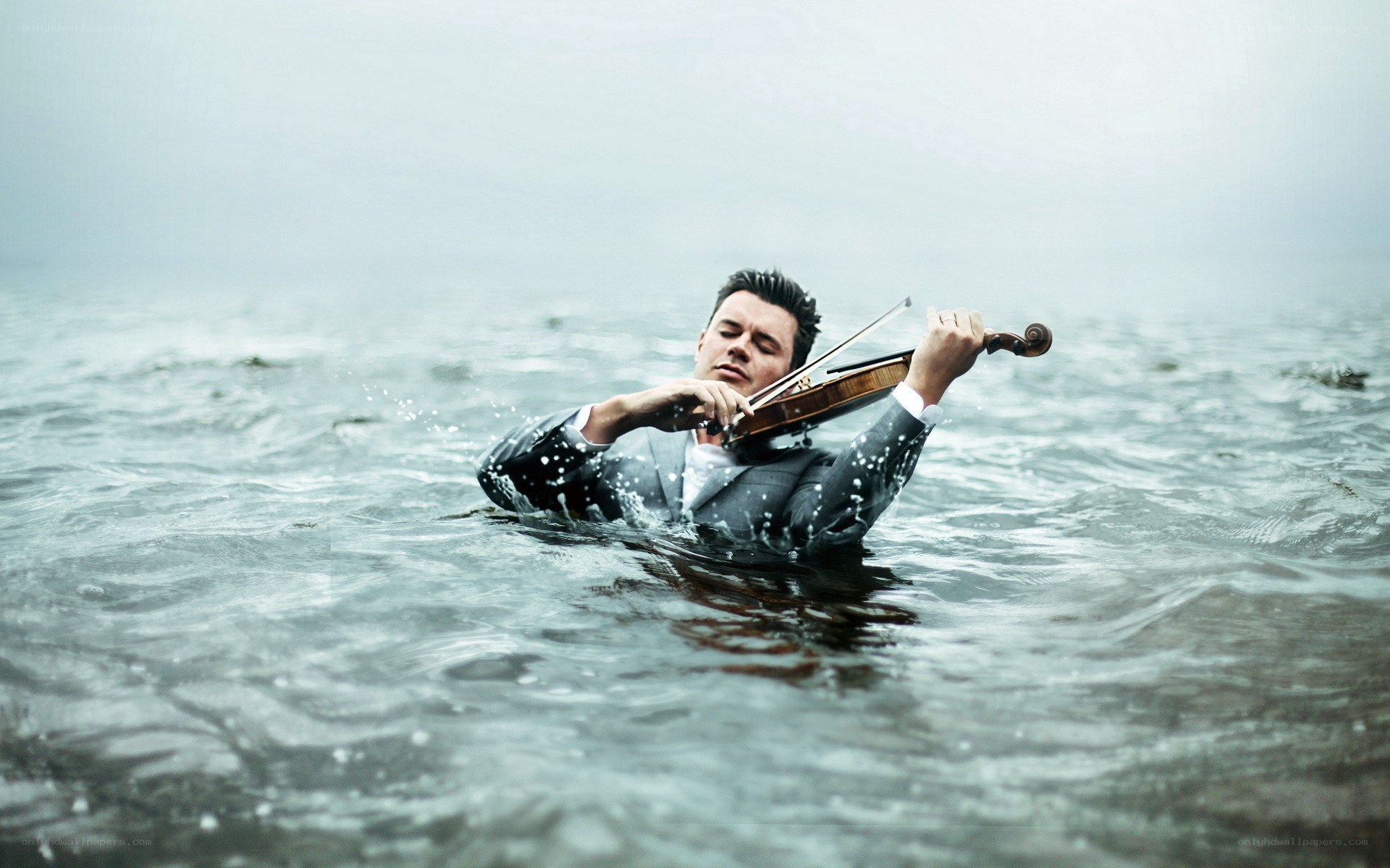 man playing violin in water