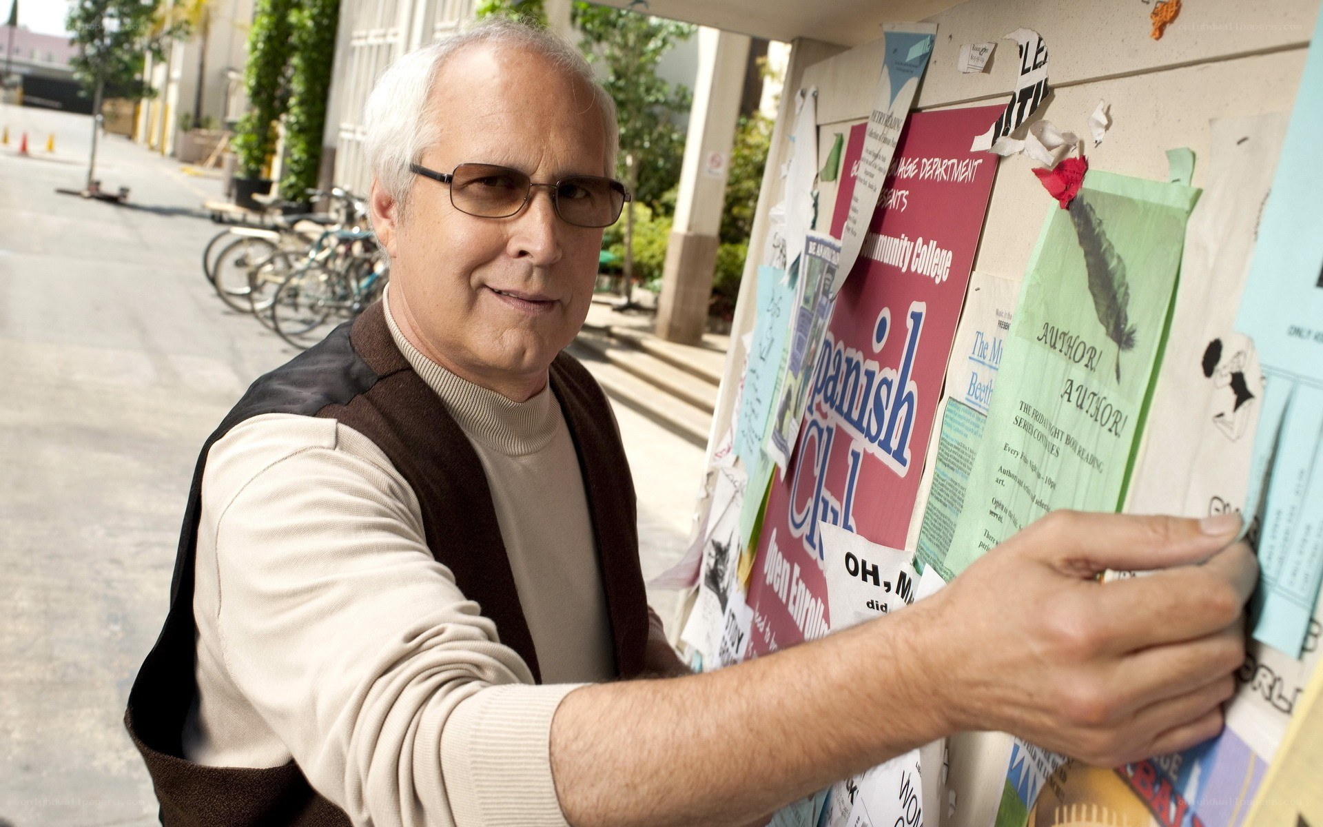 man posting flyer on bulletin board