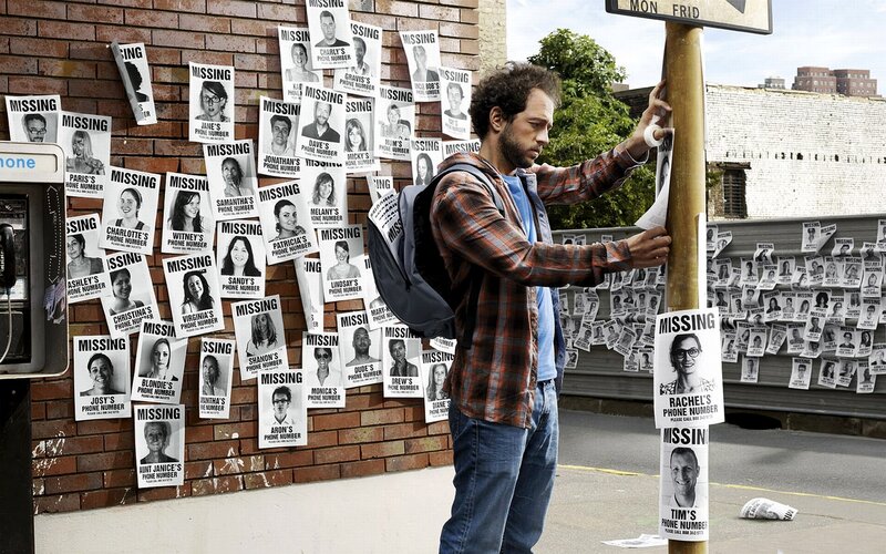 man posting missing person flyers