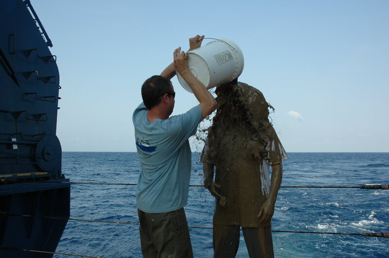 Man pouring bucket on statue