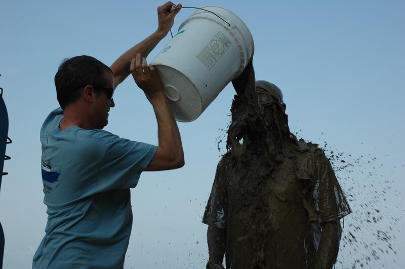 Man pouring mud on another man