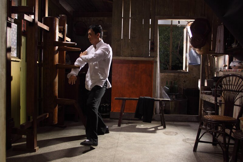 Man practicing martial arts in a wooden room