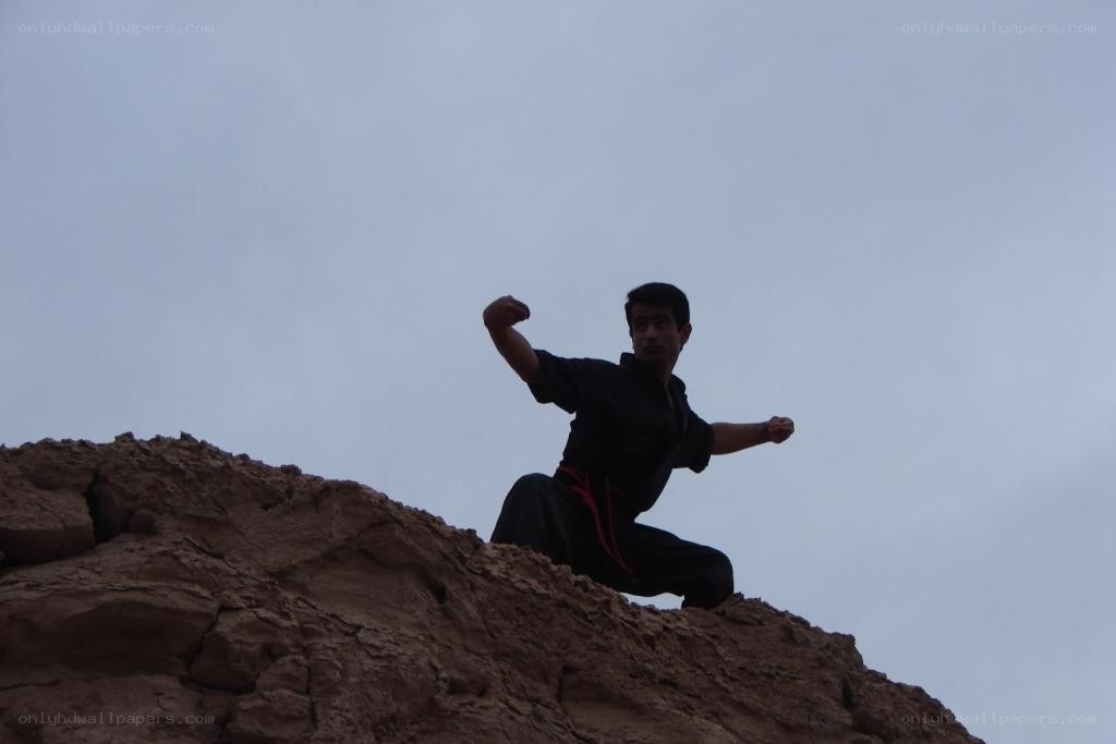 Man practicing martial arts on a cliff