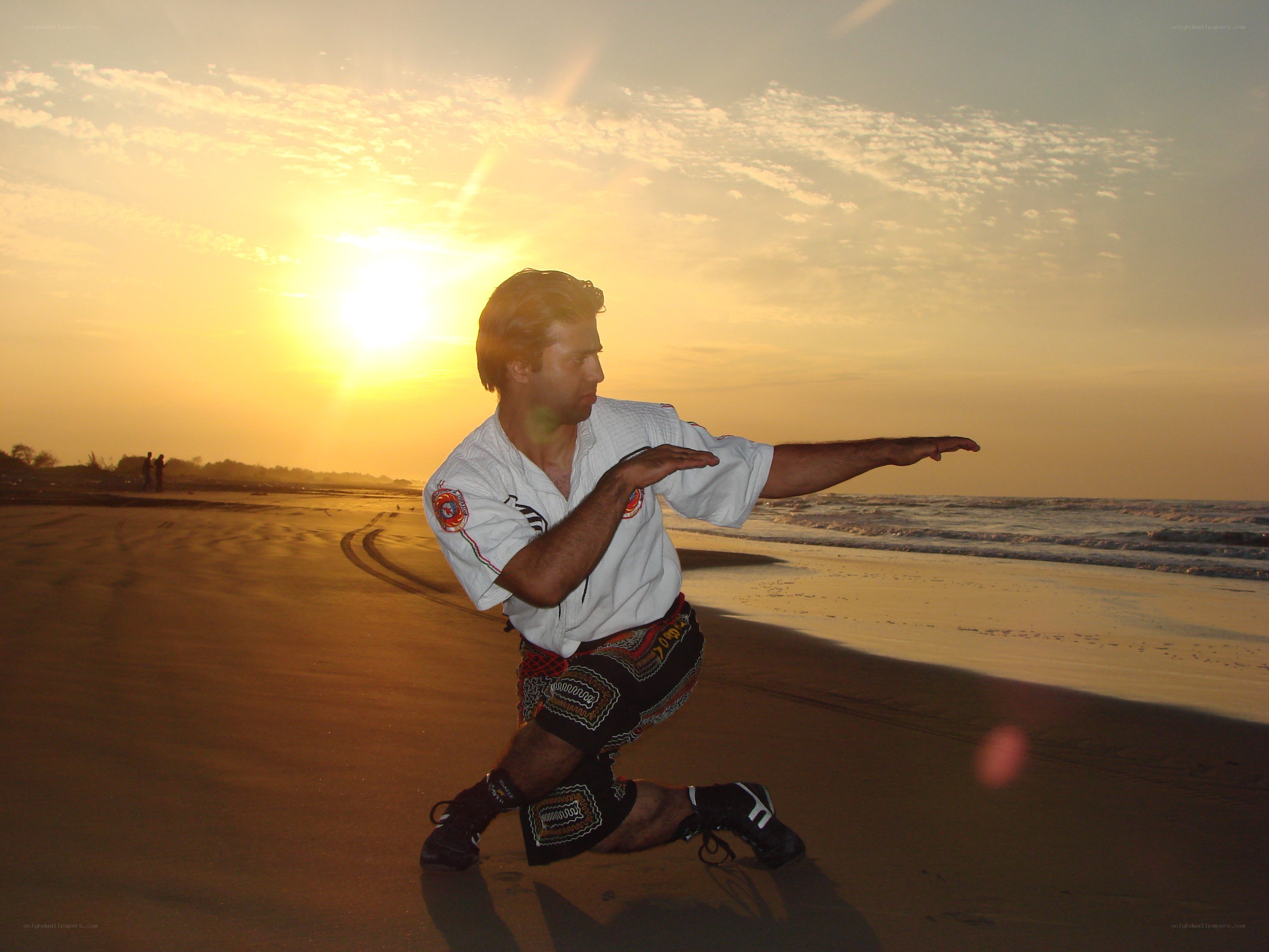 man practicing martial arts on beach