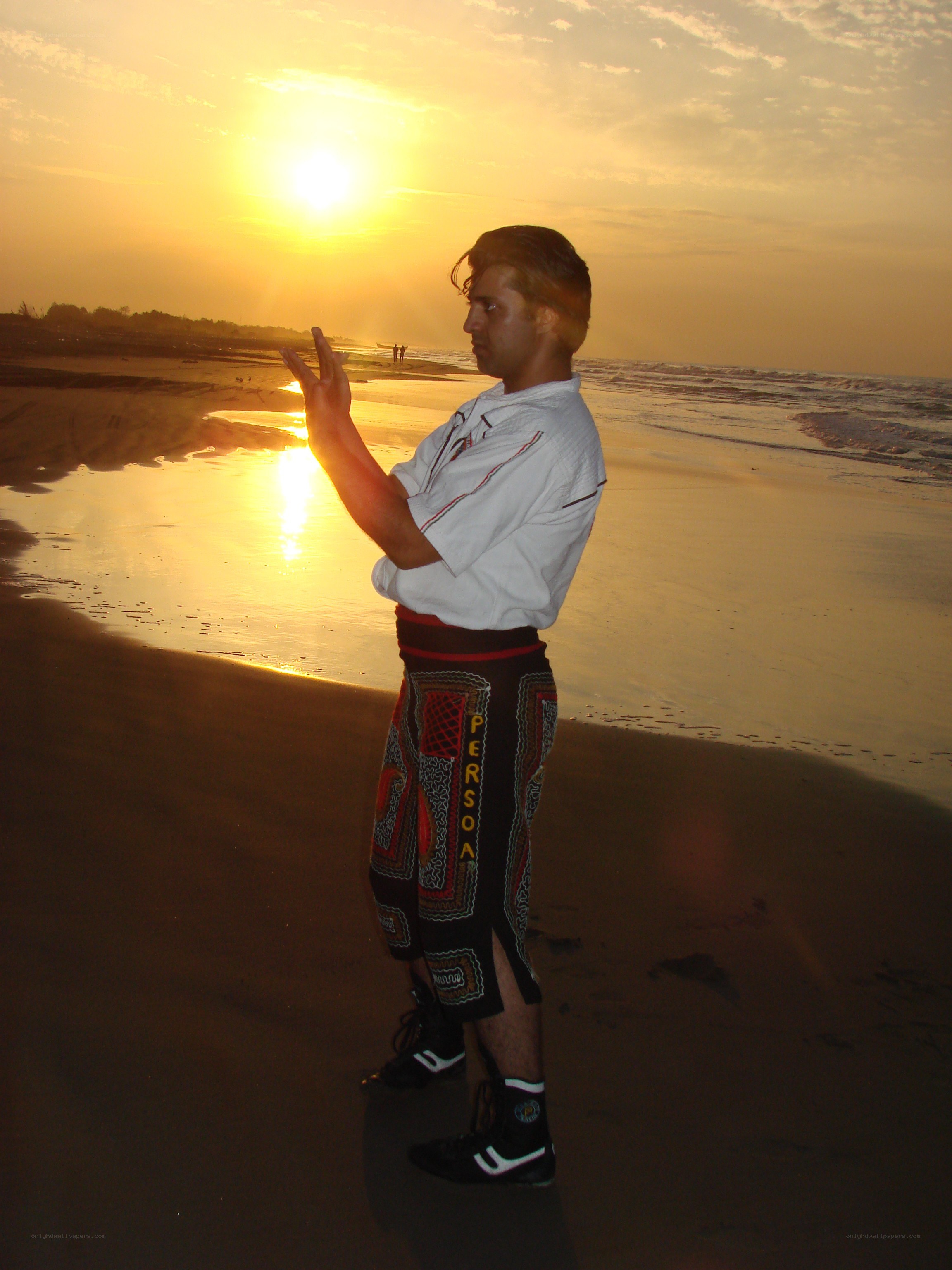 Man practicing martial arts on beach