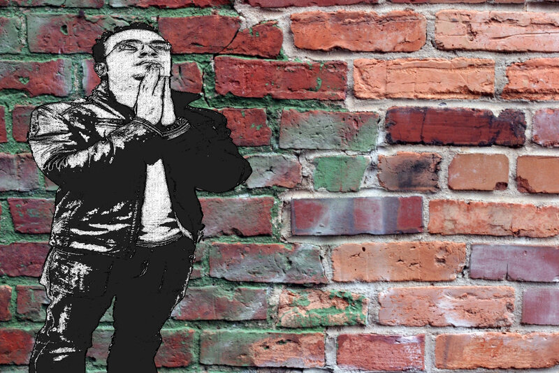 man praying against brick wall