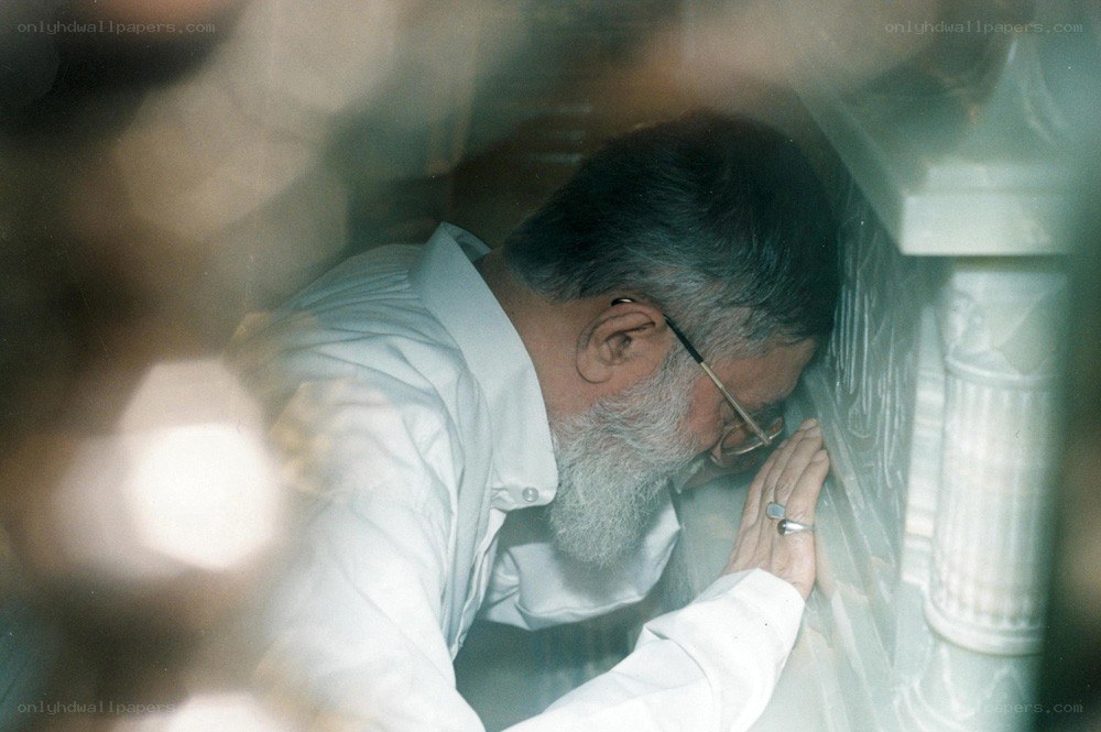 Man praying at a wall