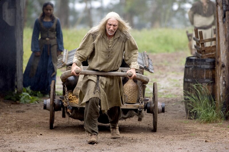 man pulling cart in rain