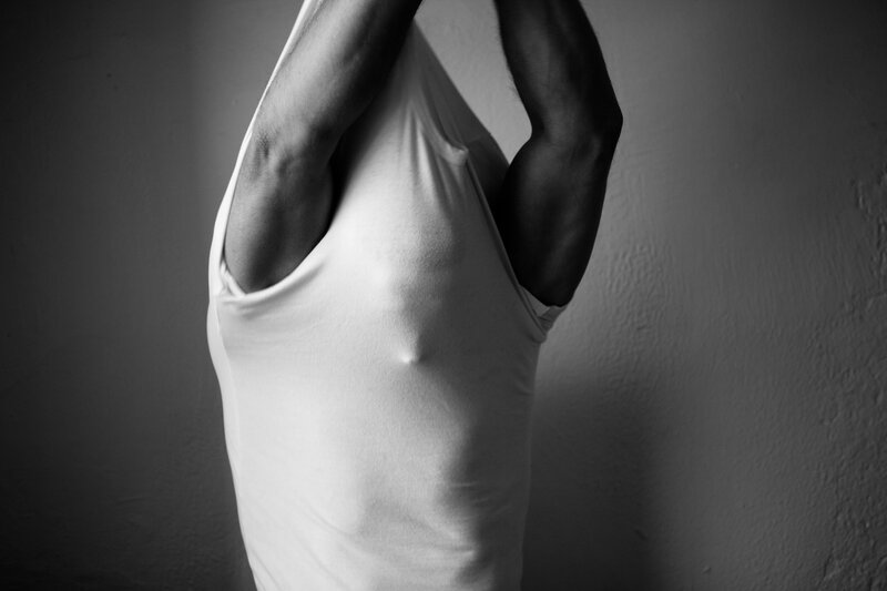 man pulling up white shirt