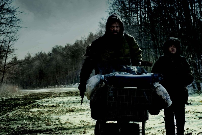 Man pushing cart with child