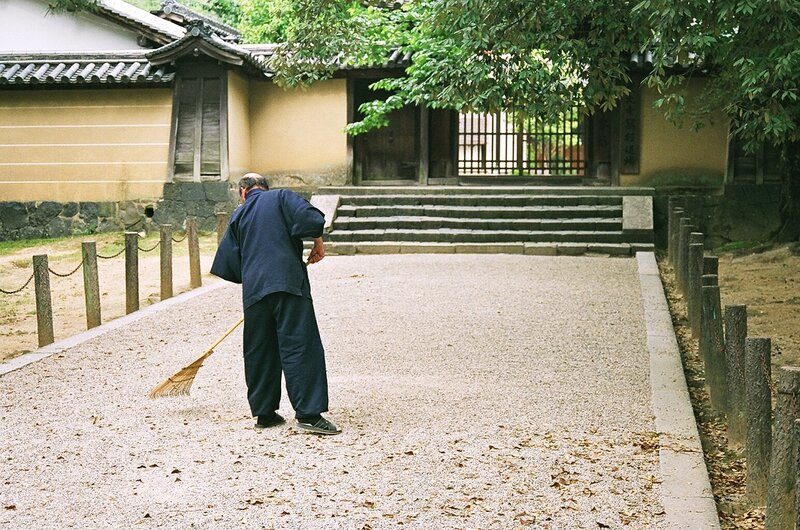 Man raking gravel in a Japanese garden