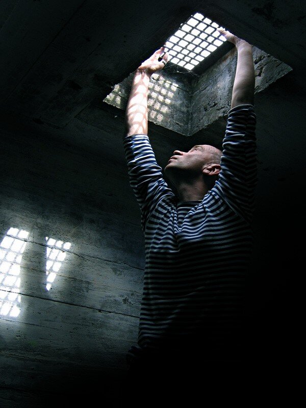 man reaching for light in prison