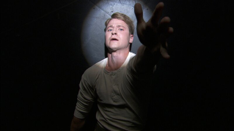 man reaching out in darkness