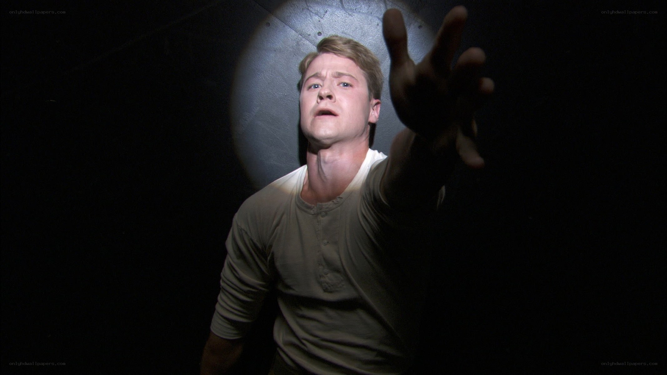 man reaching out in darkness