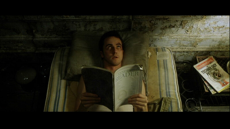 man reading book in bed