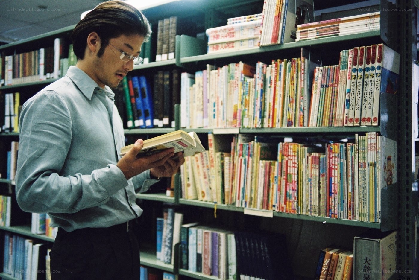 man reading book in library