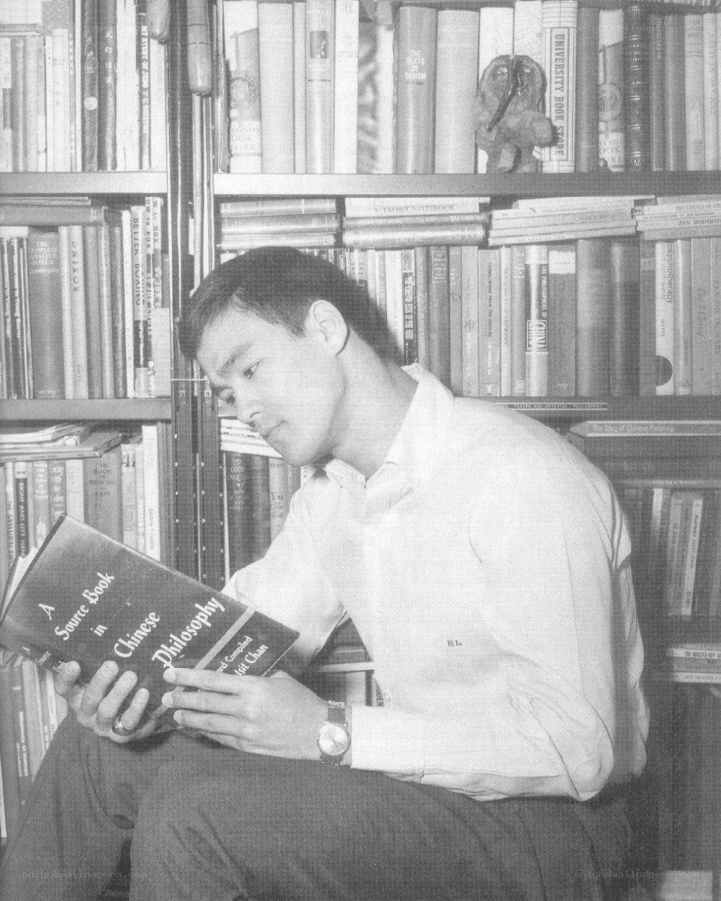 man reading book in library