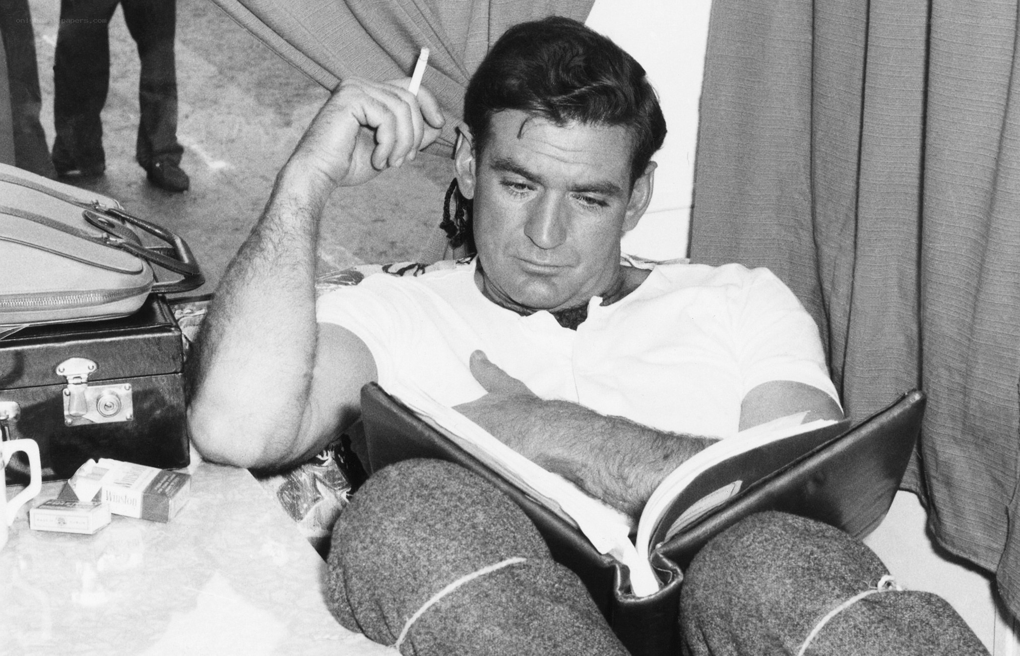 man reading book with cigarette