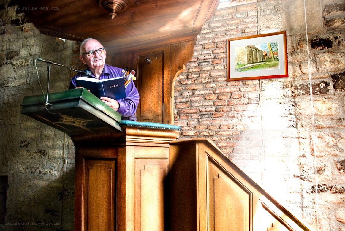 Man reading from a Bible at a pulpit
