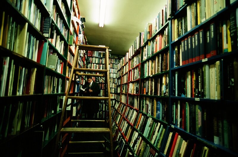 Man reading in a library aisle