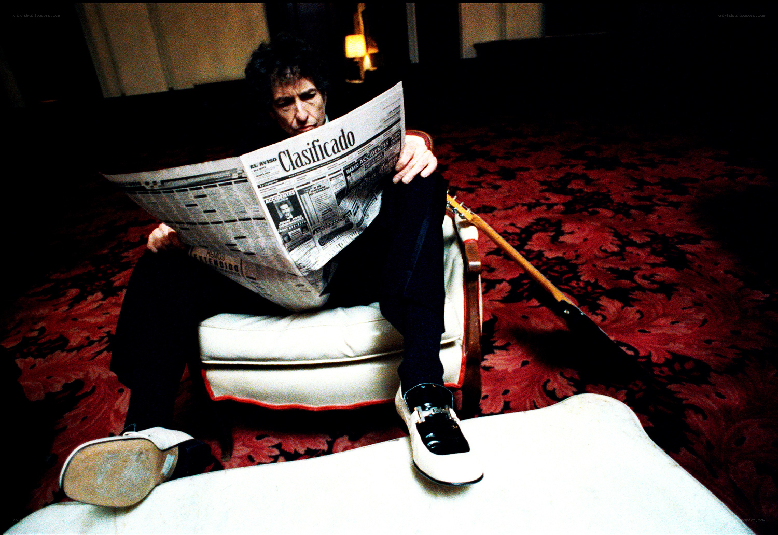 Man reading newspaper in chair