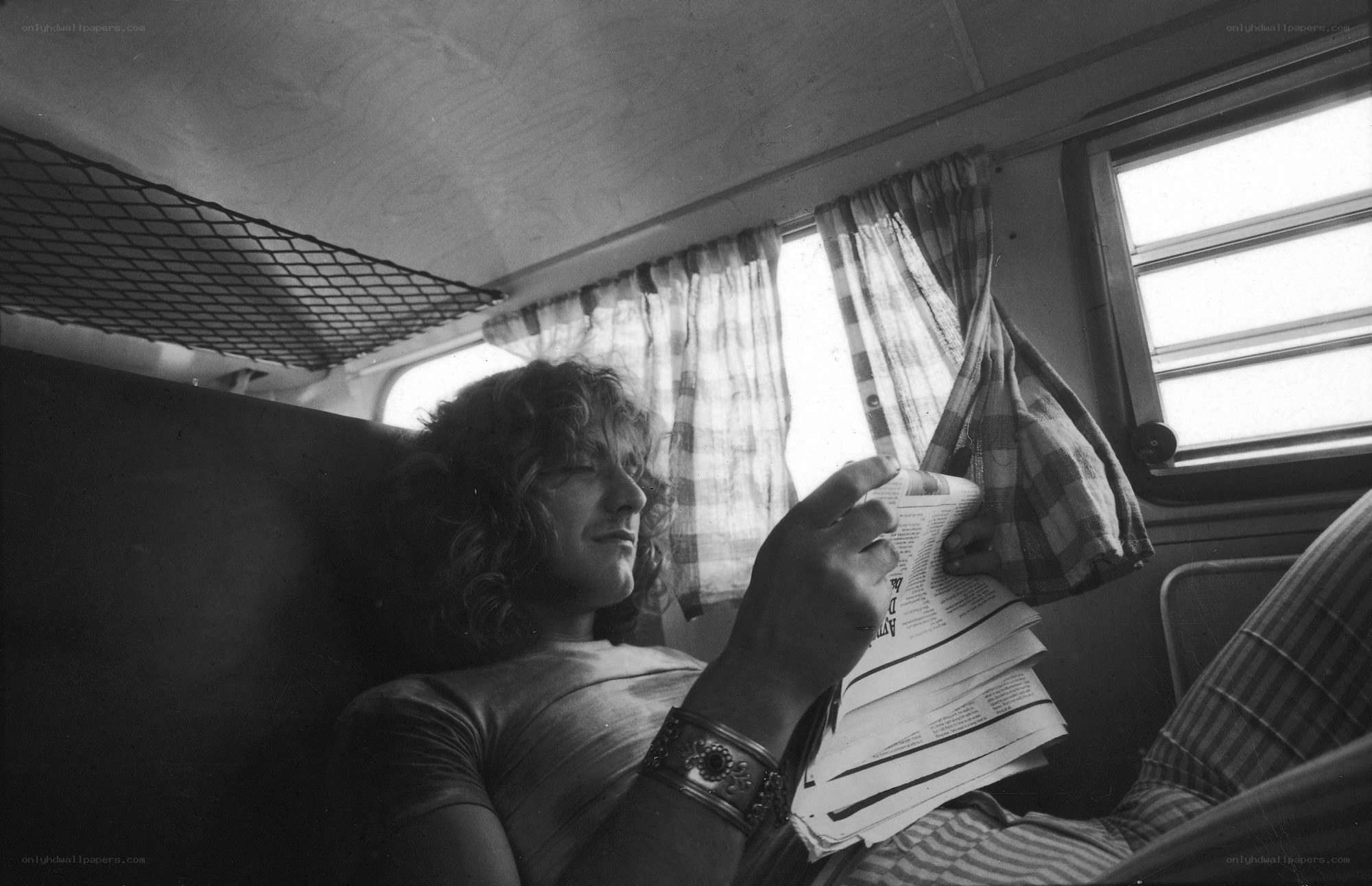 man reading newspaper in vehicle