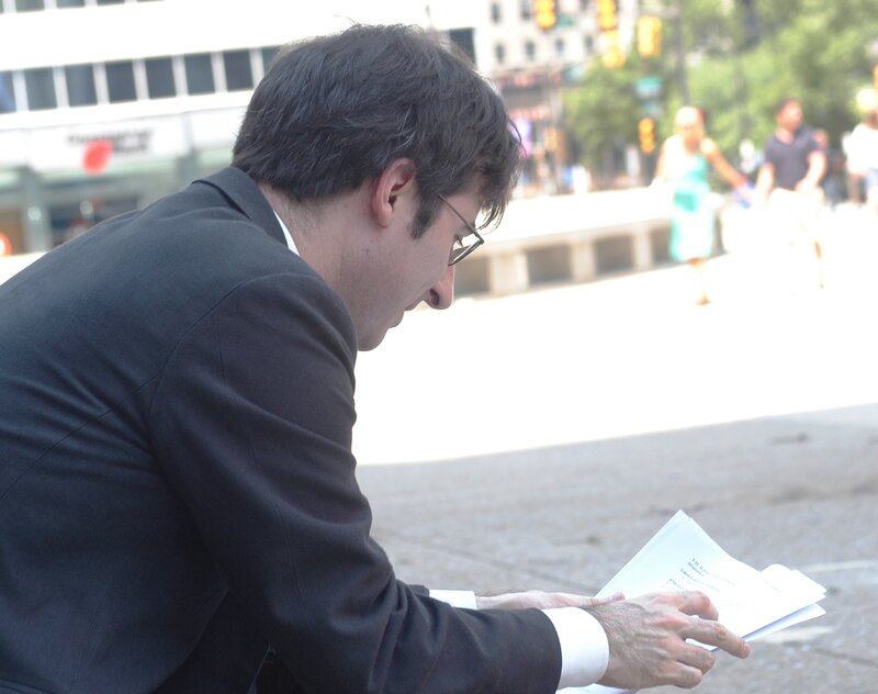 man reading papers in city