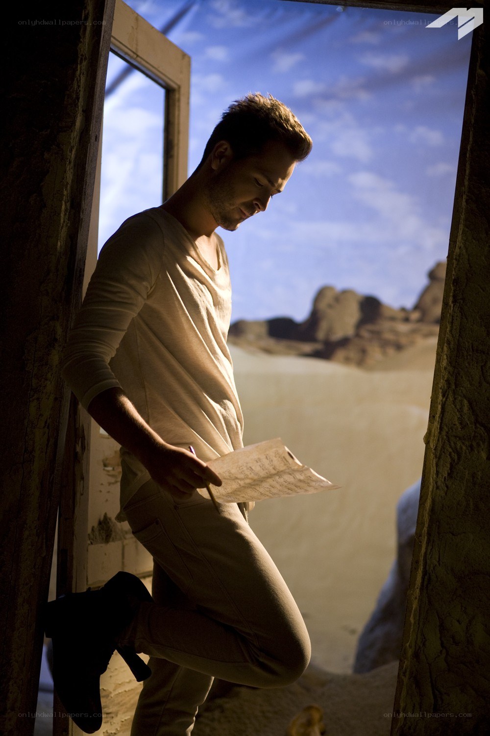 man reading sheet music in desert