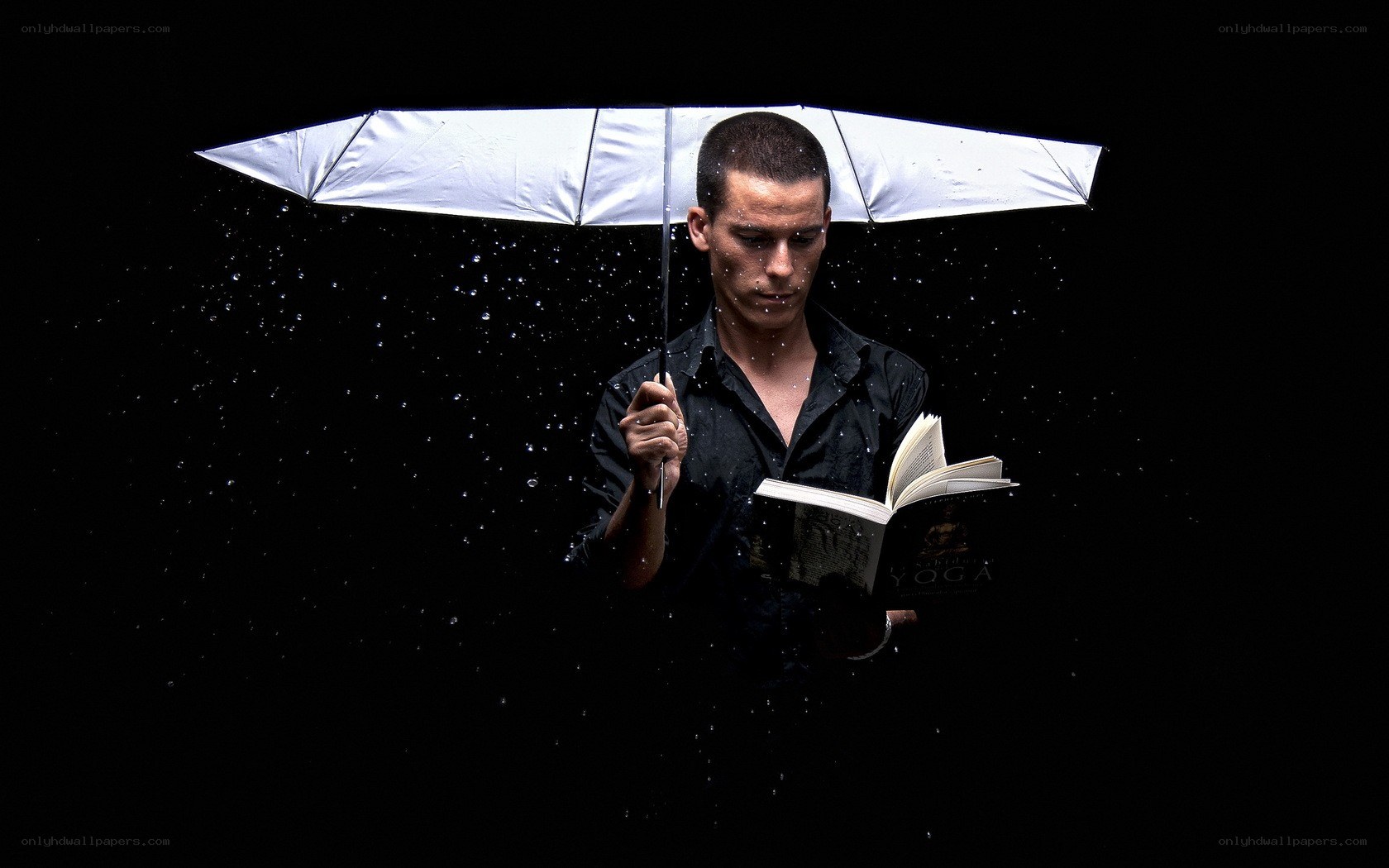 Man reading under umbrella in rain