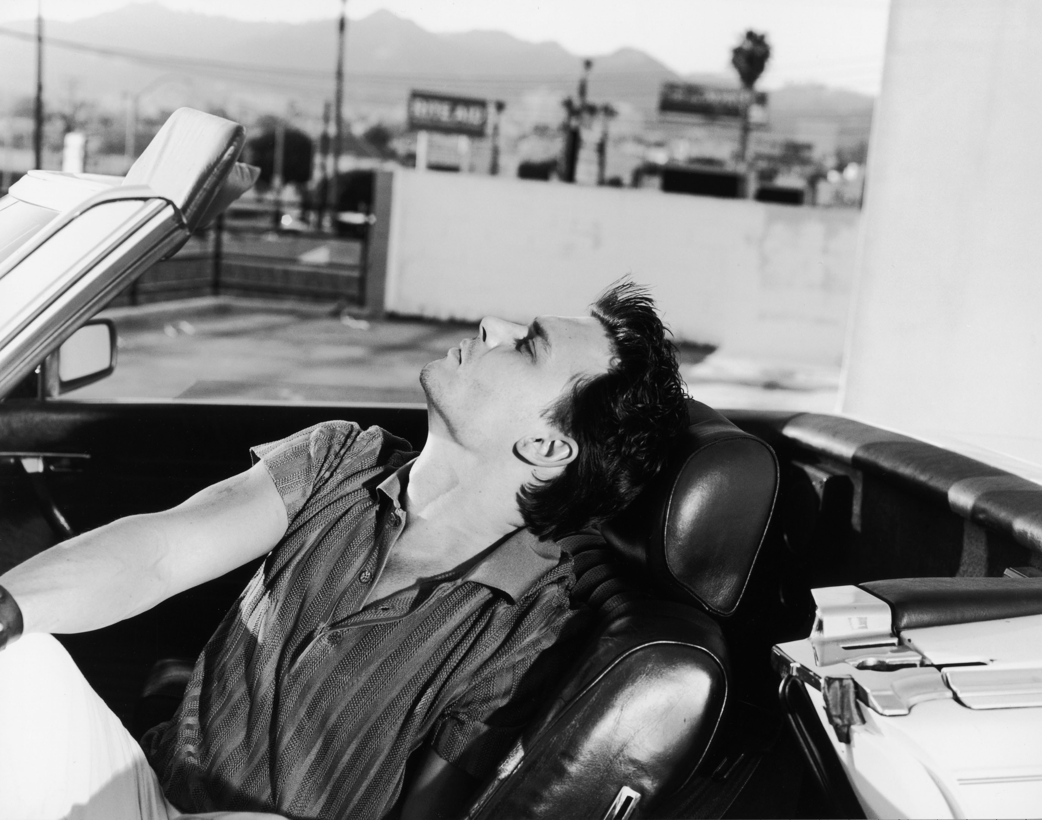 Man relaxing in convertible car