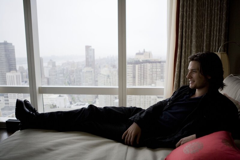 man relaxing on bed by window
