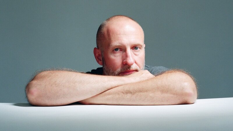 man resting arms on table