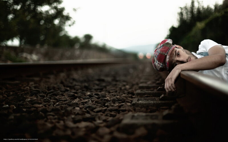 man resting on train tracks
