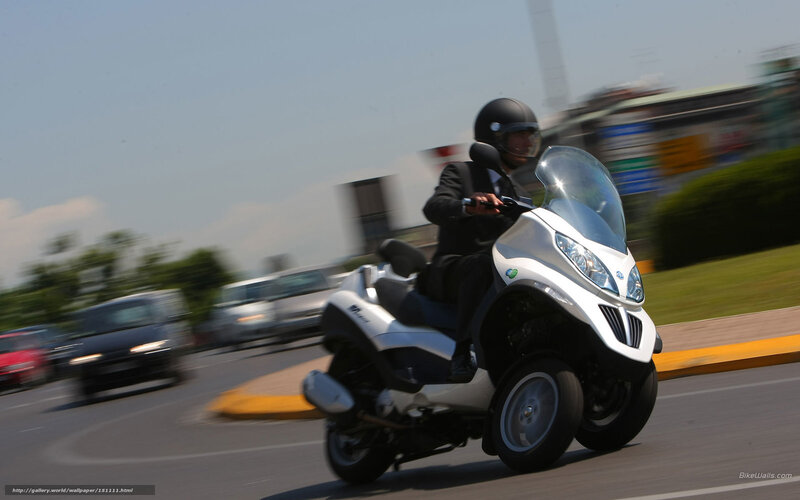 Man riding a scooter on a road